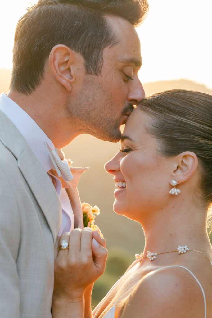 groom kissing the bride on the forehead 