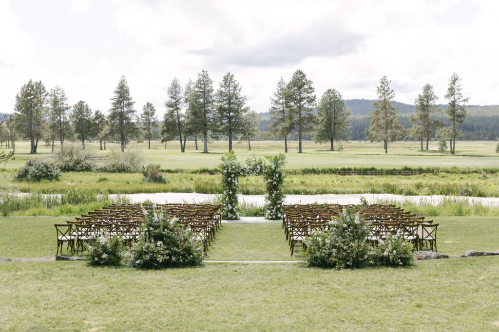 Summer wedding at Sunriver Resort, Oregon. Cereemony site with white wildflower arrangements.