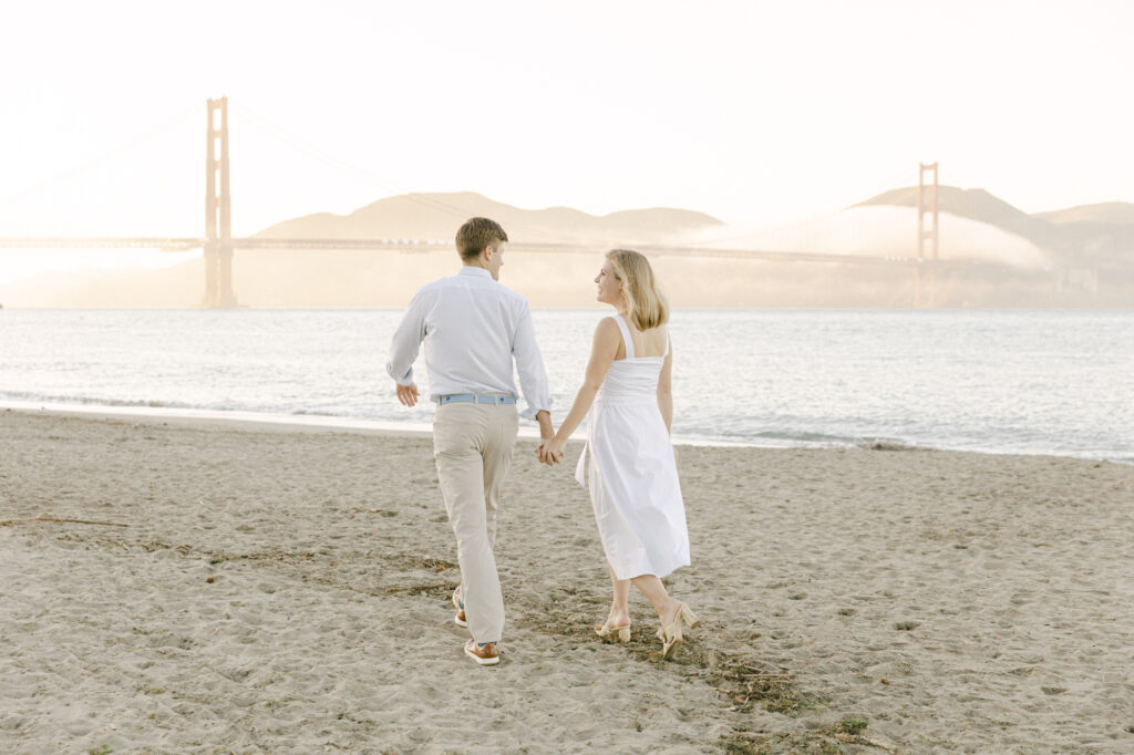 couple walking together holding hands during engagement photos in San Francisco