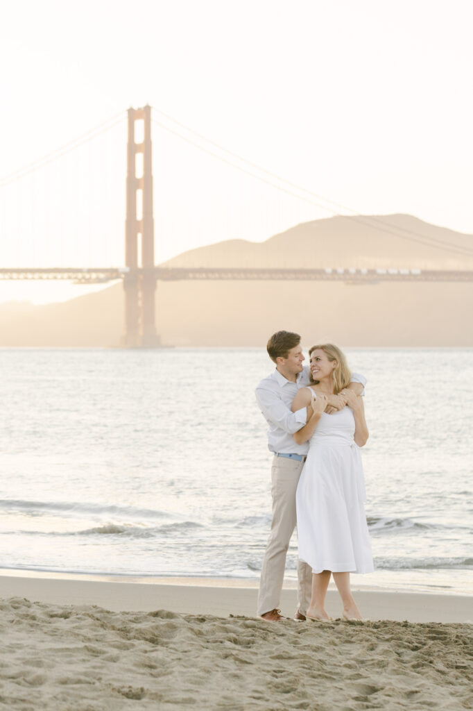 couple holding onto each other during engagement photos in san francisco