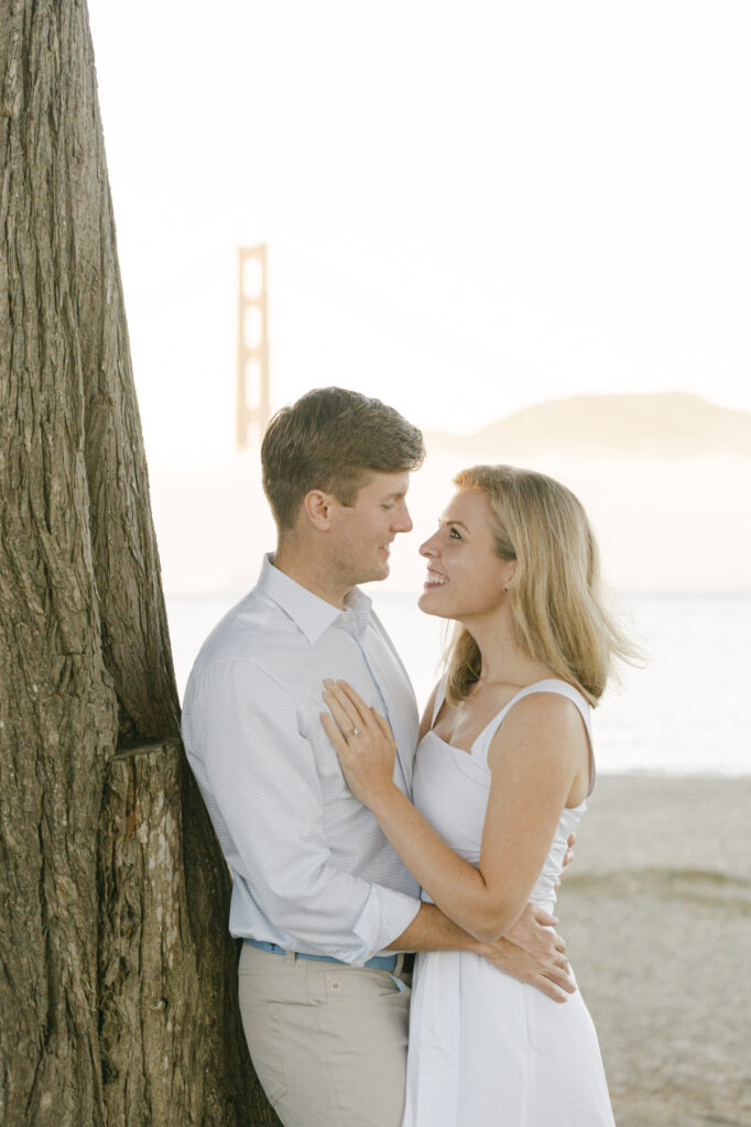 couple holding onto each other during engagement photos in san francisco