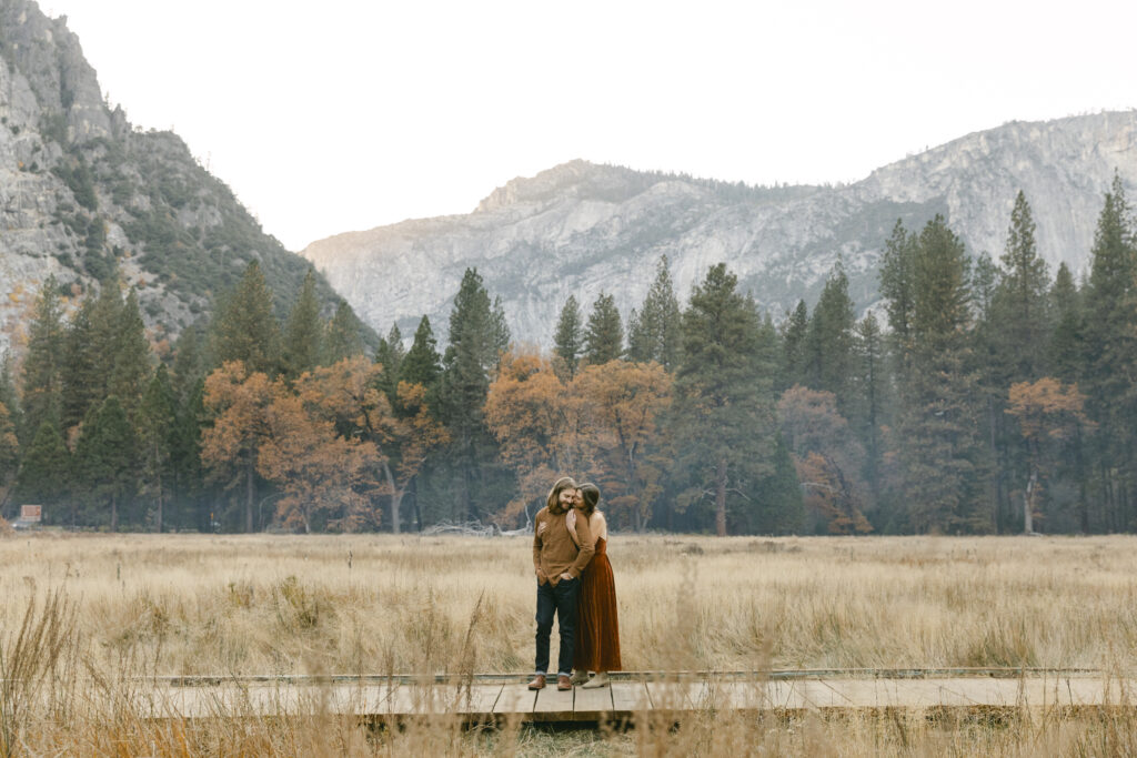 couple holding each other in front of mountside 