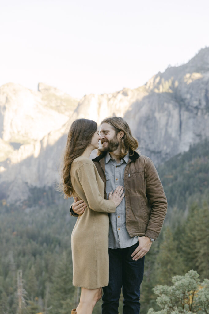 couple holding onto each other during engagement photos at yosemite national park 