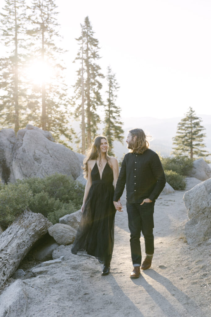 couple walking mountainside with each other during engagement photos at yosemite national park 