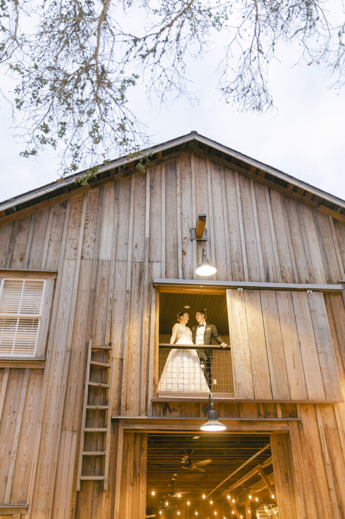 bride and groom on balcony during wedding photos in carmel