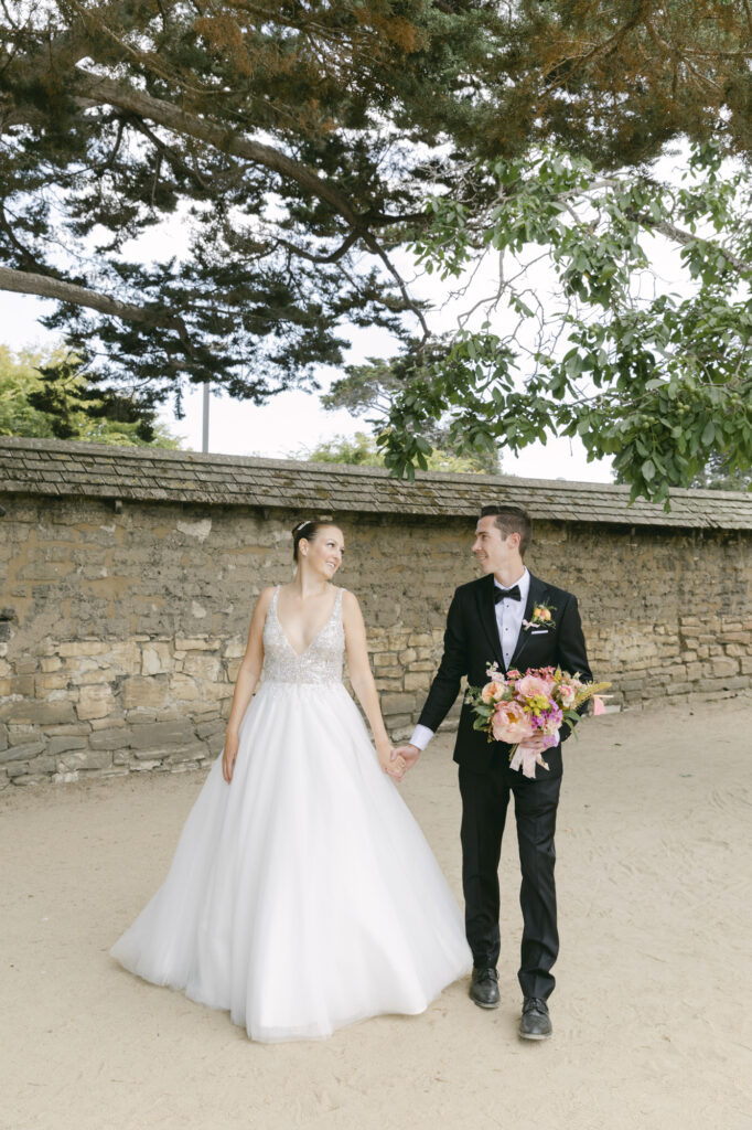 bride and groom walking holding hands during wedding photos in carmel