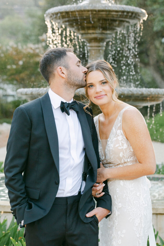 groom kissing the bride on the forehead 