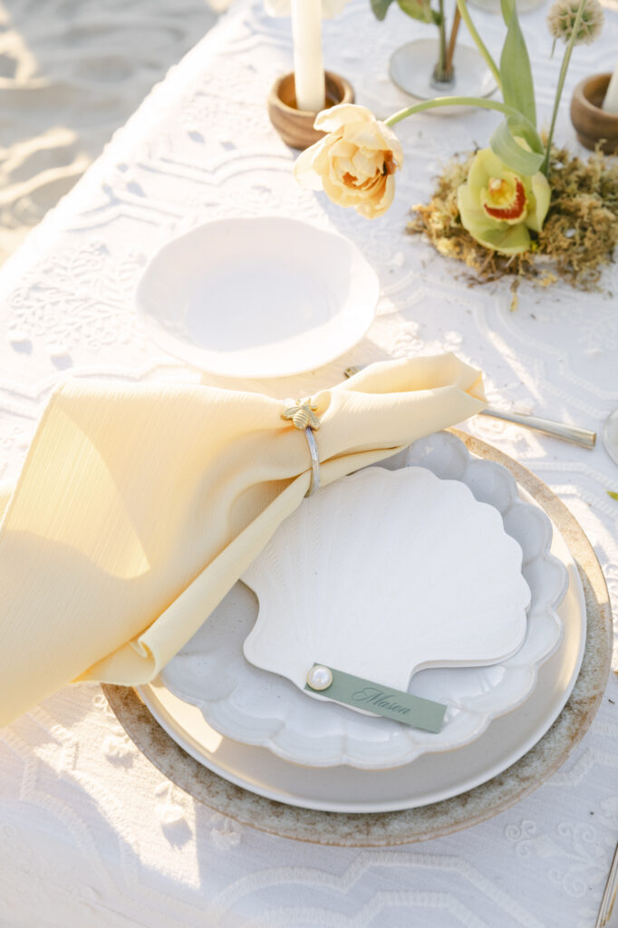 custom ivory shell shaped menus with guest names used as place cards for a beach destination wedding in San Diego.