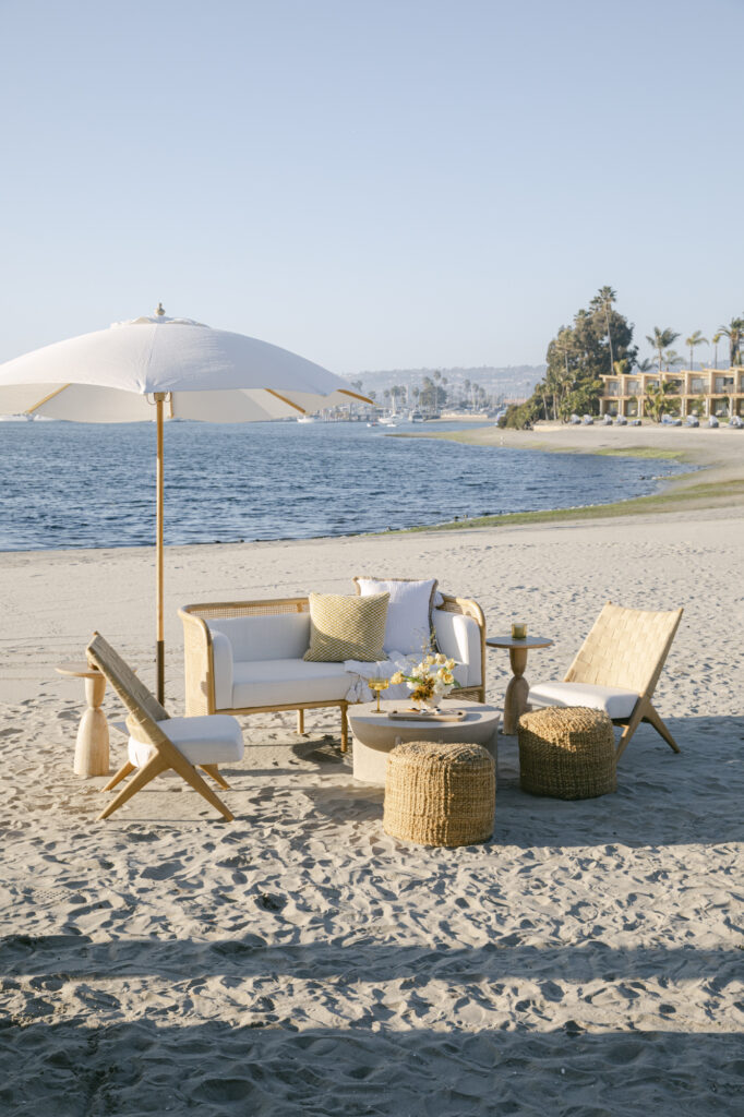 a comfy and chic seating area on the sand of a beach in San Diego for a luxury destination wedding.