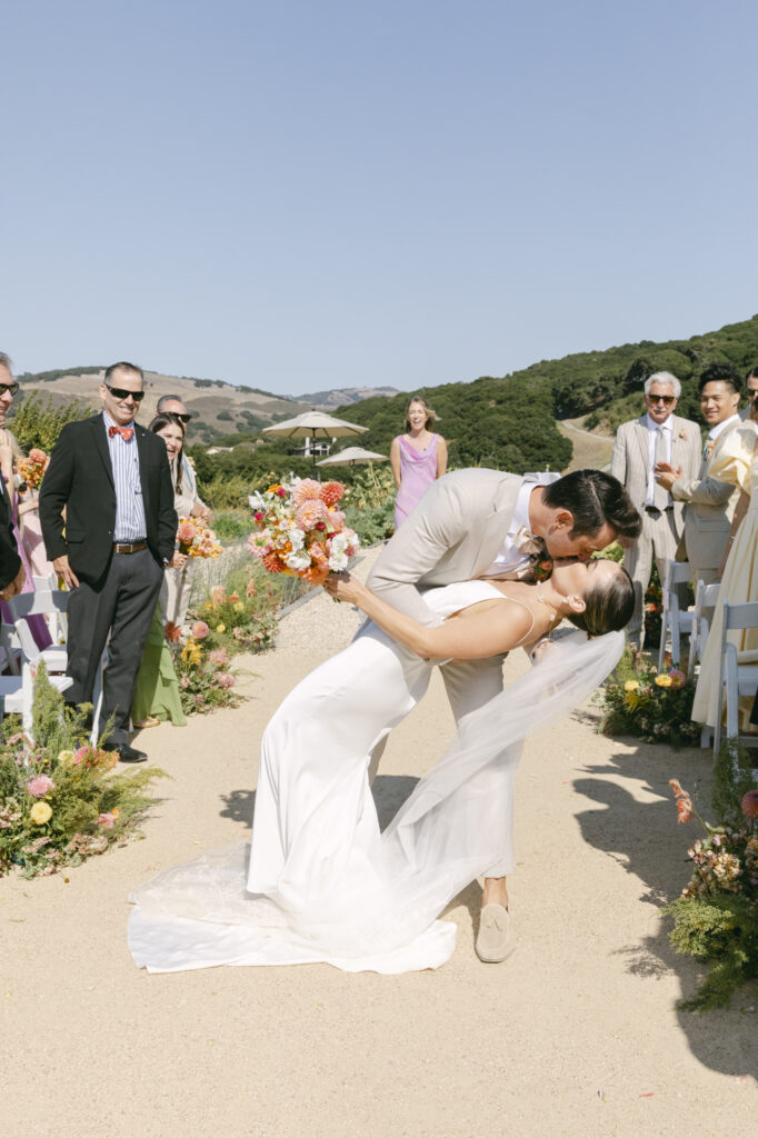 bride and groom doing a dip kiss down the aisle after becoming husband and wife. 