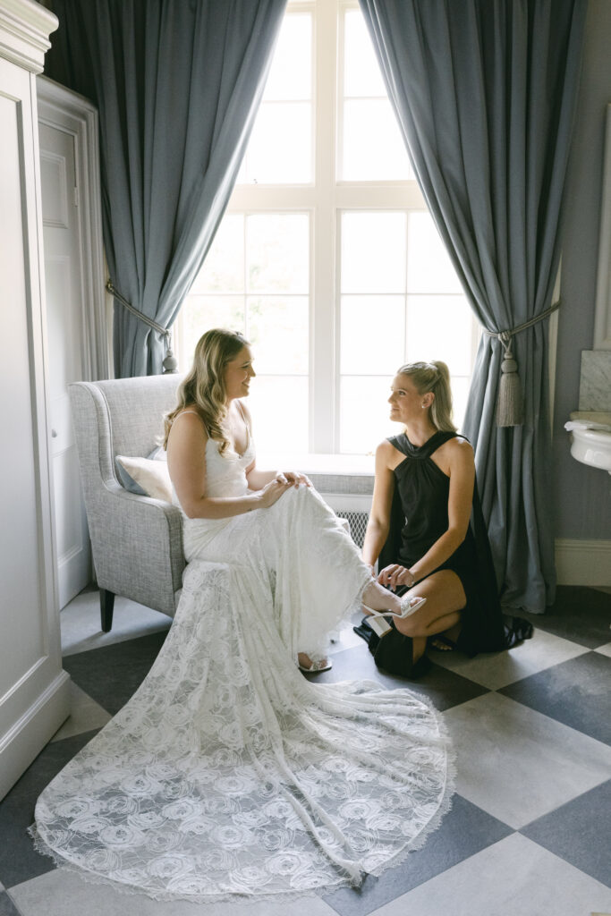 Bride at Luttrellstown Castle wedding gets her shoes on with help from her maid of honor.