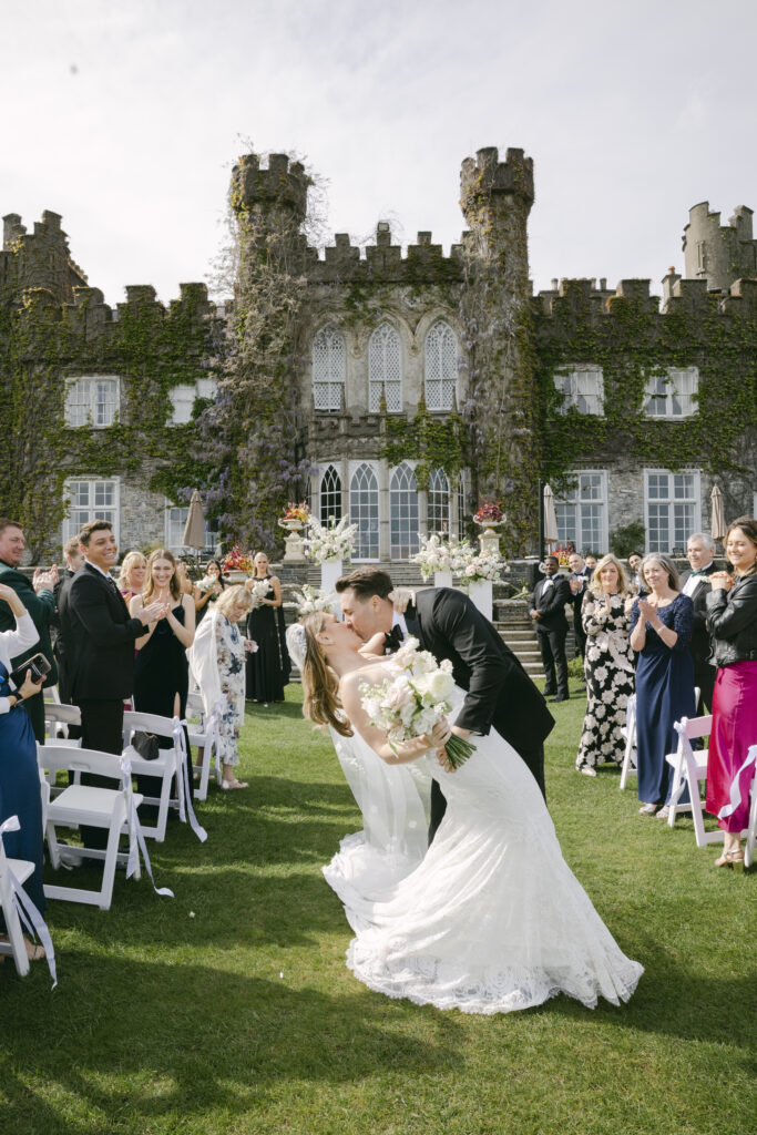 Bride and groom share a kiss after their outdoor ceremony at luxurious Luttrellstown Castle in Ireland.
