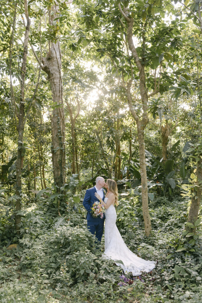 Bride and groom kissing in a sun-dappled tropical forest, luxury St. Thomas US Virgin Islands wedding photographer Paulina Perrucci