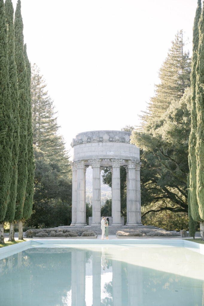 Wide view of Pulgas Water Temple with reflecting pool and couple in the distance during Bay Area engagement session