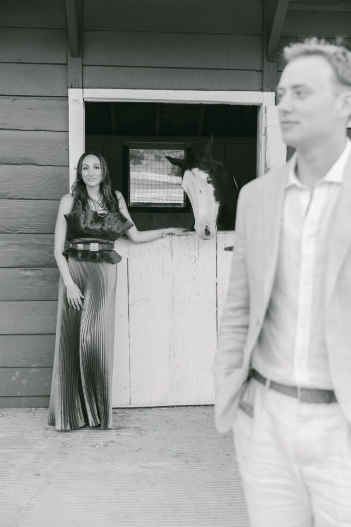 Black and white photo of a bride and groom standing together in front of the stable doors at Double H Ranch at Stonepine Estate in Carmel Valley