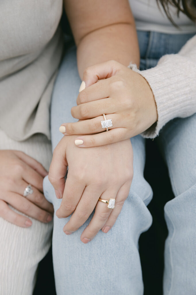 Close-up of engaged couple's linked arms showing engagement rings at Garrapata State Park near Carmel