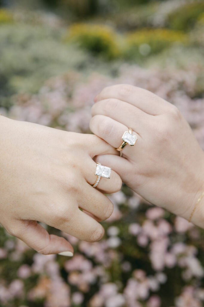 Close-up of engagement rings on couple's hands among wildflowers at Garrapata State Park near Carmel