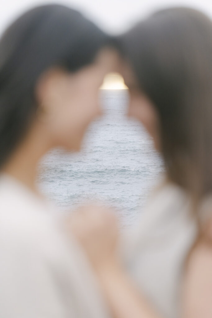 Soft focus portrait of engaged couple with ocean light between them at Garrapata State Park near Carmel
